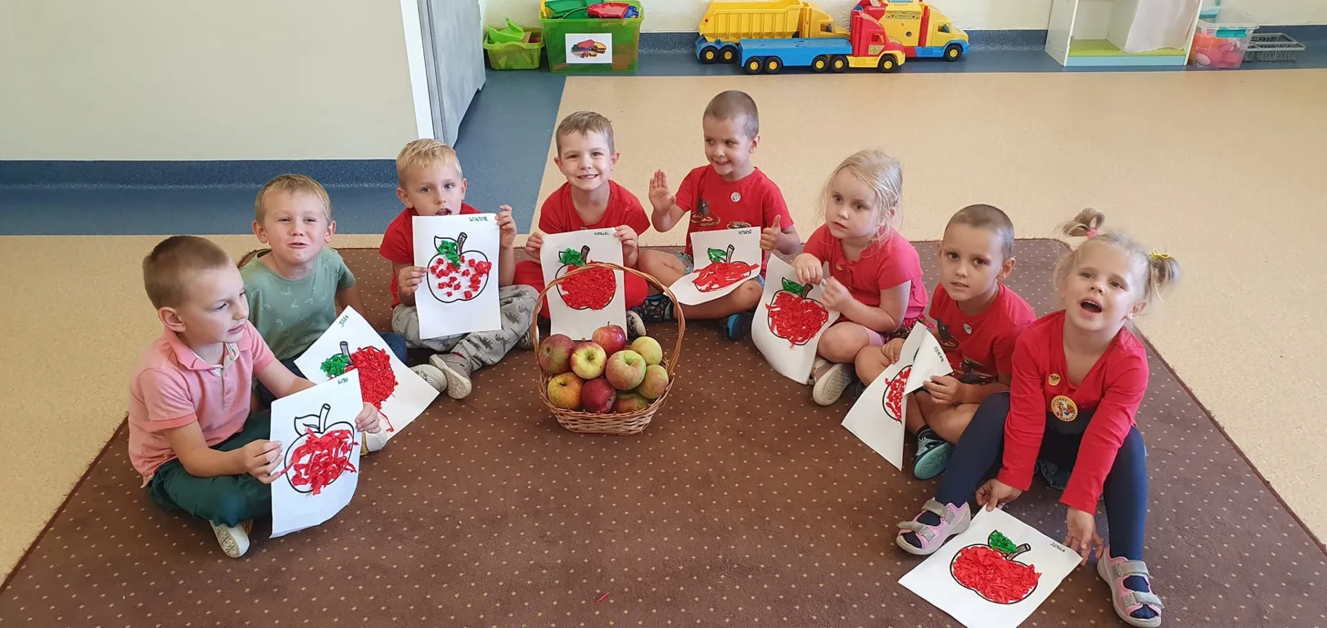 dzieci prezentujące swoje jabłka zrobione podczas zajęć plastycznych